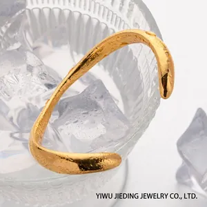 Dettaglio della trama rocciosa irregolare su bracciale in acciaio inossidabile placcato oro 18k
