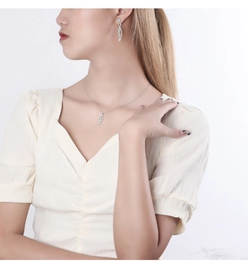 Close-up of elegant S925 sterling silver leaf necklace and earrings set on a model