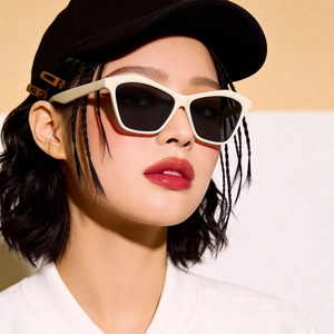 Retro cat-eye sunglasses with cream white frame and dark grey lenses on model