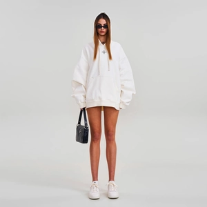 Sweat à capuche oversize blanc en coton avec motif croix, porté avec sac et baskets