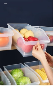 Detail view of transparent plastic storage bin with front handle for fridge organization