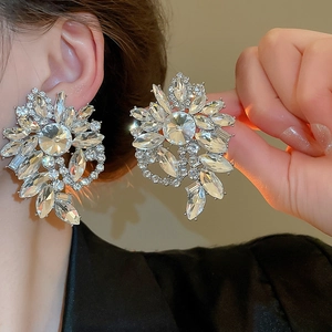 Macro detail of elegant flower stud earrings with sparkling crystals in a silver base