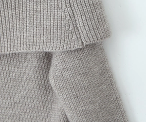 Detailed close-up of oatmeal chunky knit texture on collar and shoulder of the cardigan