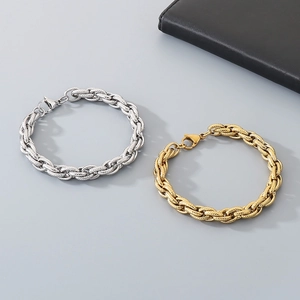 Detailed view of woven metal texture on gold and silver stainless steel bracelets