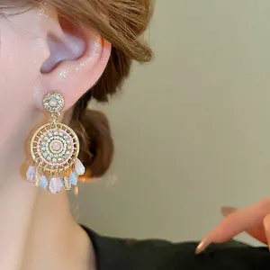 Bohemian pearl tassel earrings with gold circular frame and crystal bead accents