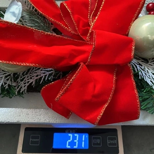 Christmas wreath detail showing a red velvet bow and golden ornaments weighing 231g