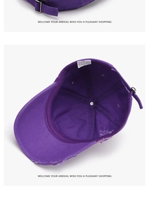 Detalle interior de una gorra de béisbol de algodón morado con bordes desgastados y copa