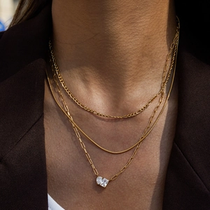 Close-up of triple-layered gold titanium necklace with CZ pendants on a female model
