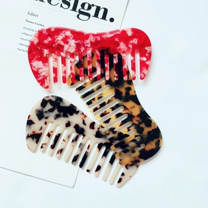 Close-up of three acetate hair combs in marble, tortoiseshell, and spotted patterns