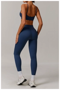 Detailed back view of navy blue high-waist yoga leggings and strappy sports bra set