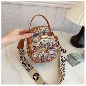 Detail view of mini teddy bear print tapestry crossbody bag with brown leather trim