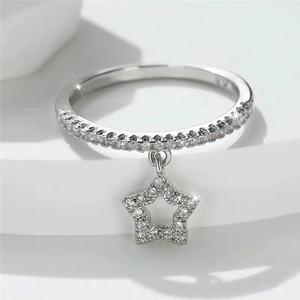 Detail shot of a 925 silver ring featuring a dangling star charm and sparkling zircons