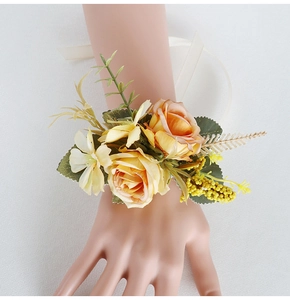 Close-up of champagne rose wrist corsage with silk ribbon and berry accents for weddings