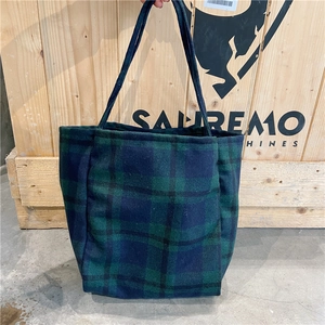 Detail of green and blue checkered wool tote bag with slim shoulder straps for daily use