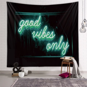 Detail of Good Vibes Only neon text tapestry hanging on a white brick wall for room decor