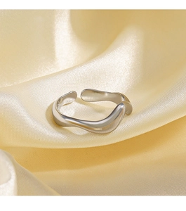 Close-up of irregular wave silver ring on champagne silk fabric with metallic luster