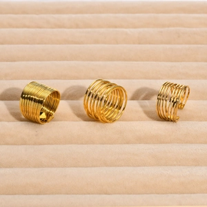 Three gold layered multi-strand stainless steel rings on a beige velvet jewelry tray