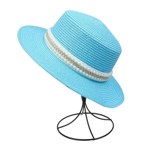 Close-up of blue woven straw hat featuring artificial pearl and gold chain detail
