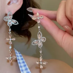 Silver needle butterfly tassel earrings with pink crystals and hollow floral drop design
