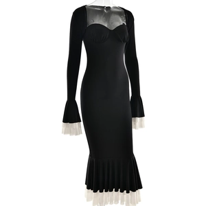Close-up of elegant black slim-fit dress featuring white ruffled cuffs and hemline detail