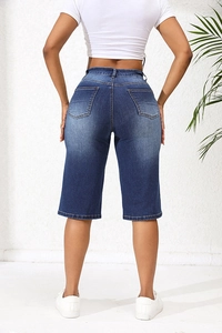 Gros plan sur le short en jean bleu taille haute avec coutures de qualité et poches