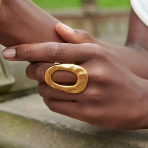 Bague irrégulière en acier inoxydable doré à texture martelée portée au doigt
