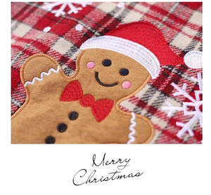 Macro detail of gingerbread man applique and snowflake embroidery on Xmas stocking