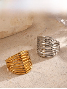 Detailed view of wide hollow multilayered line rings in gold and silver finish