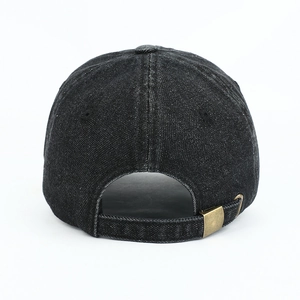 Detail view of adjustable bronze buckle and stitching on washed denim baseball cap