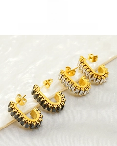 Detail showing J-shaped gold earrings with black and clear cubic zirconia insets