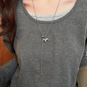 Close-up of silver zircon horse pendant necklace with adjustable snake chain on model