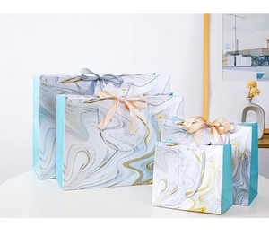 Detail view of marble patterned gift bags in four sizes with elegant ribbon bow handles