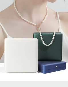 Detail of luxury crown pearl necklace boxes in white, green and blue satin finish
