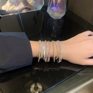 Macro shot of gold-plated stacked crystal bracelets set on elegant black background