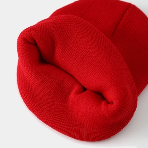 Detailed close-up of thick red knit beanie showing fine texture and warmth