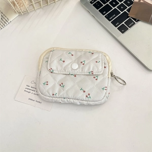Detailed shot of quilted floral coin purse with cherry print and secure ring zipper closure