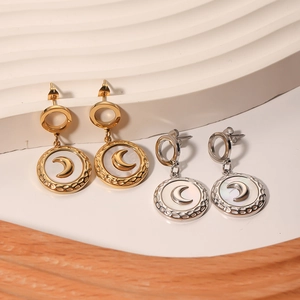 Golden and silver stainless steel moon pearl earrings on a wave jewelry display stand
