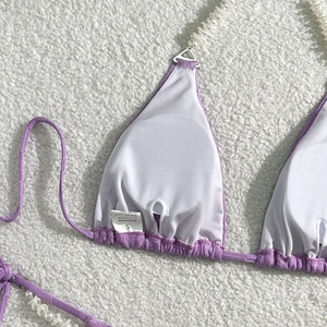 Close-up of purple bikini top featuring faux pearl straps and soft white interior lining