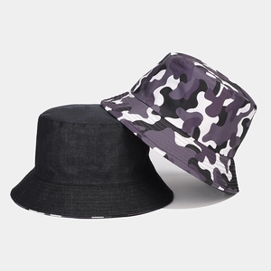 Detail view of double-sided bucket hats in solid black cotton and purple camouflage print
