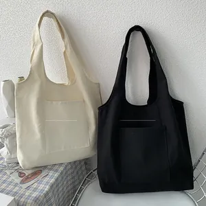 Detail showing solid black and white canvas tote bags with front pockets and large capacity