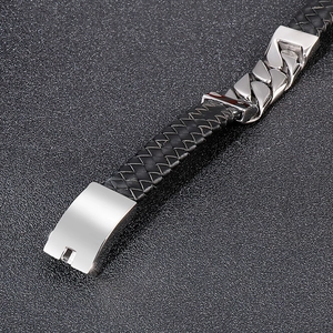 Detail of black braided leather men's bracelet with polished steel Cuban chain link