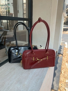 Outdoor shot of vintage black and burgundy leather bowling bags with metal buckles
