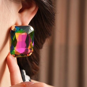 Macro side view of a model wearing vintage rectangle rhinestone earrings with colorful stones