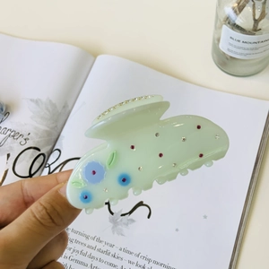 Pince à cheveux fleurie en acétate vert menthe avec strass dans un décor de style