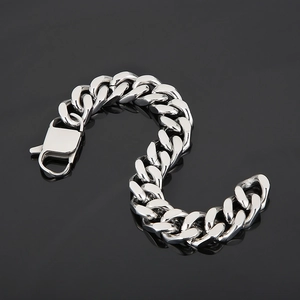 Detailed view of silver Cuban link chain bracelet with lobster clasp on black background