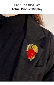 Close-up of strawberry enamel brooch pinned on a black suit jacket for fashion detail