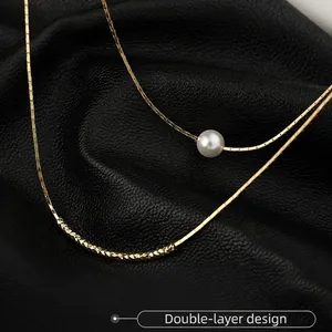 Golden double-layer baroque pearl necklace with textured curved tube in a minimalist style