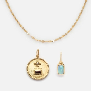 Close-up of gold stainless steel necklace with square opal and red zircon cross charms