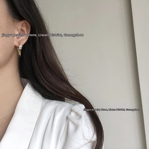 Detailed close-up of 18K gold-plated chain earrings with white mother-of-pearl flowers