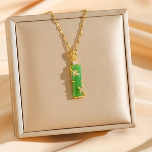 Collier élégant en acier titane doré avec pendentif bambou vert sur fond de soie fine